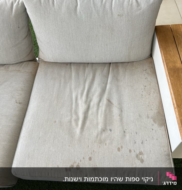 כרית ספה עם כתמים כהים על בד בהיר